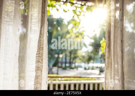 Le matin, le soleil brille sur la porte à travers les rideaux blancs. Banque D'Images