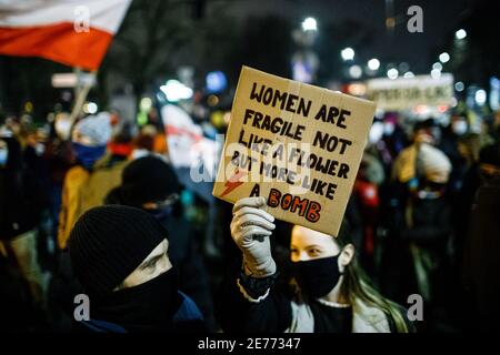 Krakow, Pologne. 27 janvier 2021. Un manifestant portant un masque facial porte un écriteau disant que la femme est fragile, non pas comme une fleur mais comme une bombe pendant la manifestation.après que le verdict de la Cour constitutionnelle polonaise de mettre en œuvre l'une des lois anti-avortement les plus restrictives d'Europe est entré en vigueur le 27 janvier, Des centaines de Polonais ont pris les rues dans toutes les grandes villes. Les manifestations organisées par la grève des femmes ont éclaté à nouveau après l'adoption du nouveau projet de loi anti-avortement. Crédit : SOPA Images Limited/Alamy Live News Banque D'Images