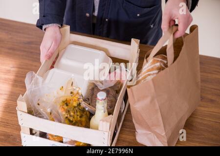 Nuremberg, Allemagne. 22 janvier 2021. Une cliente de Mobile Culinary School emballe ses aliments précommandés dans une boîte en bois. De nombreux restaurants offrent des menus de haute qualité pour le ramassage pendant le confinement. C'est également le cas avec Mobile Kochkunst à Nuremberg, qui propose un forfait week-end avec salade, soupe, plat principal avec viande et accompagnement, et un dessert tous les vendredis. (À dpa 'manger à l'écluse - entre plaisir de cuisine et frustration') Credit: Daniel Karmann/dpa/Alamy Live News Banque D'Images