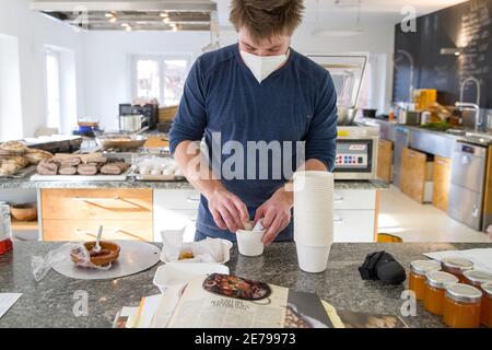 Nuremberg, Allemagne. 22 janvier 2021. Manuel Kohler, chef de l'école culinaire mobile, prépare les plats commandés dans la cuisine pour les plats à emporter. De nombreux restaurants proposent des menus de haute qualité pour être ramassent pendant le confinement. C'est également le cas au Mobile Kochkunst de Nuremberg, qui propose un forfait week-end chaque vendredi avec salade, soupe, plat principal avec viande et accompagnement, et un dessert. (À dpa 'manger à l'écluse - entre plaisir de cuisine et frustration') Credit: Daniel Karmann/dpa/Alamy Live News Banque D'Images