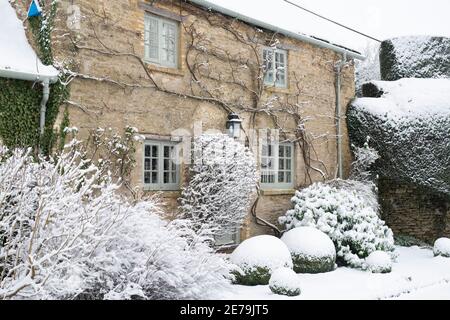 Cotswold cottage en pierre à Swinbrook dans la neige. Swinbrook, Cotswolds, Oxfordshire, Angleterre Banque D'Images