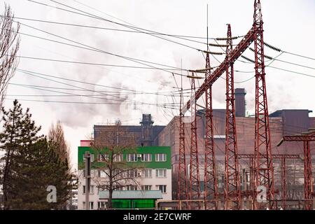 lignes électriques haute tension sur le fond des tuyaux de fumée d'une usine métallurgique. Banque D'Images