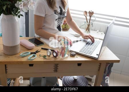 Femme caucasienne travaillant à la maison avec son ordinateur portable et son ordinateur portable dans un environnement calme et propre. Banque D'Images
