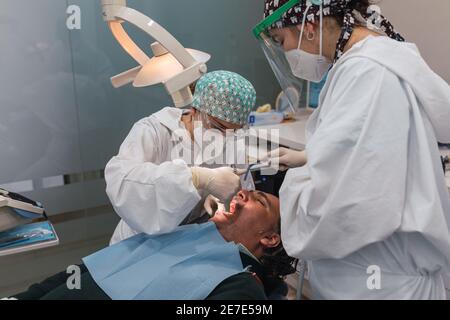 Chirurgien dentaire injectant l'anesthésie dans la bouche. Trois personnes. Concept de santé dentaire Banque D'Images