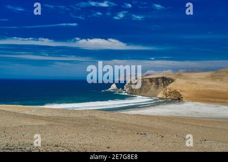 Desolate et vaste paysage de Paracas sur la côte du Pérou, un endroit où le désert rencontre l'océan. Ciel bleu, nuages et un désert de sable Banque D'Images