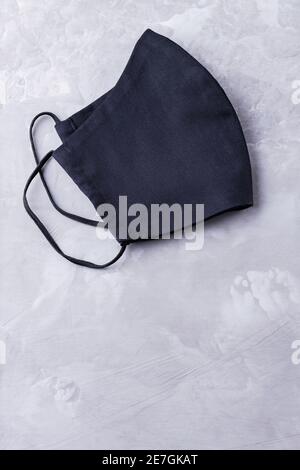 Masque de protection du visage sur fond gris ultime. Masque antivirus en coton noir. Masque fait maison à visage noir pour protéger contre la grippe et le virus. Co Banque D'Images