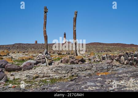 Phare construit de briques rouges, situé sur la rocheuse isla pinguino sur la côte de Patagonie en Argentine, encadré au milieu de deux poteaux en bois Banque D'Images