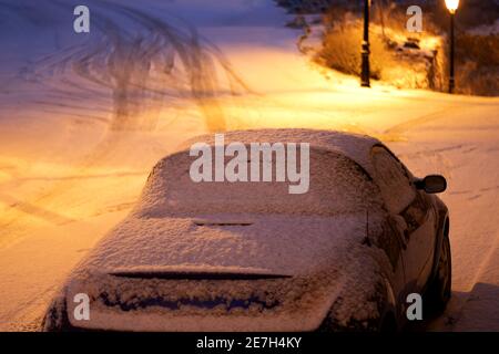 Une voiture enterrée par la neige par la tempête Philomena illuminée par les feux de circulation Banque D'Images