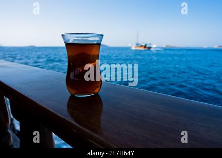 Dégustez une tasse de thé turc sur un bateau en direction de l'île de Kekova, près de la ville de Kas, en Turquie Banque D'Images