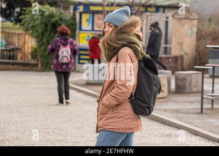 Prague, République tchèque. 01-29-2021. Portrait d'une jeune femme élégante marchant dans le centre de Prague pendant une matinée d'hiver ensoleillée et froide. Banque D'Images