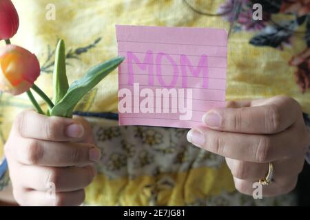 fête des mères concept de femmes tenant la fleur de tulipe et collant remarque Banque D'Images
