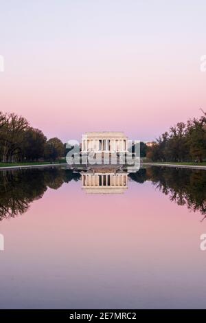 Un ciel rose et le légendaire Lincoln Memorial en marbre d'ivoire sont mis en miroir dans la piscine à l'occasion d'une matinée d'automne à Washington, DC. Situé à l' Banque D'Images