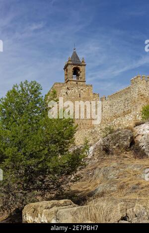 Le clocher de l'Alcazaba d'Antequera, situé à un coin des murs extérieurs en pierre des forts, sur une colline escarpée couverte de rochers dans la ville. Banque D'Images