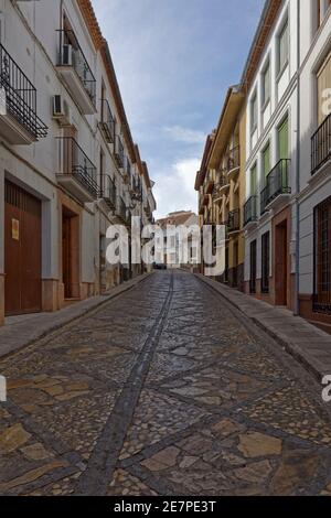 Une étroite rue pavée décorative dans la ville médiévale d'Antequerra en Andalousie lors d'une soirée tranquille en mai. Banque D'Images