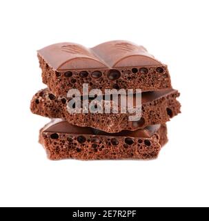 Morceaux de chocolat poreux isolés sur fond blanc. Chocolat noir gazéifié. Banque D'Images