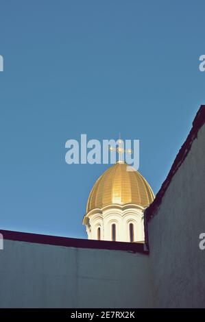 Une tour d'or de l'église orthodoxe avec une croix sur le dessus, derrière un mur, vue de dessous, espace de copie Banque D'Images