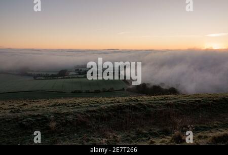 Une belle vue au lever du soleil de Pewsey Vale avec la brume qui s'élève comme un tsunami, vue de Martinsell Hill, Wiltshire, North Wessex Downs AONB Banque D'Images