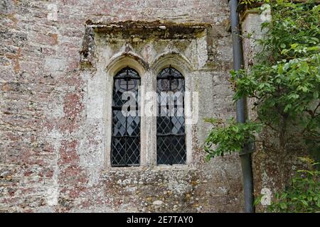 Une ancienne fenêtre voûtée au plomb avec un cadre en béton Une ancienne maison de campagne anglaise Banque D'Images
