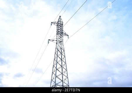 Tour d'électricité moyenne tension sur la montagne. Fond bleu ciel avec nuages. Banque D'Images
