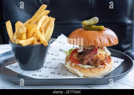 Sheffield, Royaume-Uni - 03 août 2017 : fromage de poulet et hamburger au bacon servis avec des frites à OHM, Fitzwilliam Street Banque D'Images