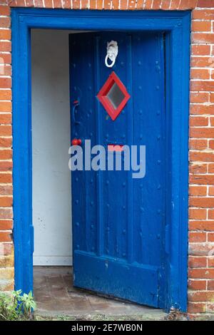 bleu vif rouge accents très ancienne porte d'entrée de chalet en bois Banque D'Images