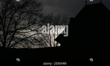 Le soleil se couche dans la cour d'un château médiéval et baigne le monde dans une humeur sombre et sinistre Banque D'Images