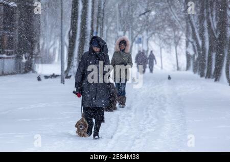 Riga, Lettonie. 30 janvier 2021. Les gens marchent dans la neige à Riga, en Lettonie, le 30 janvier 2021. Un cyclone avec un centre à la frontière entre l'Estonie et la Russie a provoqué une longue période de fortes chutes de neige en Lettonie ce week-end, ont déclaré des météorologues samedi. Le Centre letton de l'environnement, de la géologie et de la météorologie a émis un avertissement orange sur les chutes de neige et les blizzards, qui devaient augmenter la couverture de neige déjà épaisse dans les parties nord du pays et la capitale Riga de 20 centimètres d'ici dimanche matin. Crédit: Edijs Palens/Xinhua/Alamy Live News Banque D'Images