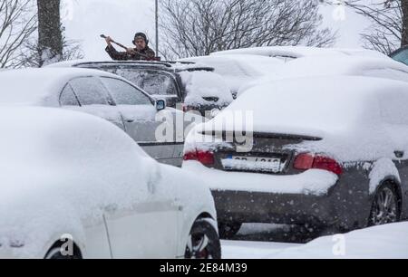 Riga, Lettonie. 30 janvier 2021. Un homme enlève la neige d'un véhicule à Riga, en Lettonie, le 30 janvier 2021. Un cyclone avec un centre à la frontière entre l'Estonie et la Russie a provoqué une longue période de fortes chutes de neige en Lettonie ce week-end, ont déclaré des météorologues samedi. Le Centre letton de l'environnement, de la géologie et de la météorologie a émis un avertissement orange sur les chutes de neige et les blizzards, qui devaient augmenter la couverture de neige déjà épaisse dans les parties nord du pays et la capitale Riga de 20 centimètres d'ici dimanche matin. Crédit: Edijs Palens/Xinhua/Alamy Live News Banque D'Images