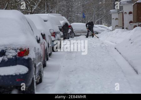 Riga, Lettonie. 30 janvier 2021. Un homme déneigement à Riga, en Lettonie, le 30 janvier 2021. Un cyclone avec un centre à la frontière entre l'Estonie et la Russie a provoqué une longue période de fortes chutes de neige en Lettonie ce week-end, ont déclaré des météorologues samedi. Le Centre letton de l'environnement, de la géologie et de la météorologie a émis un avertissement orange sur les chutes de neige et les blizzards, qui devaient augmenter la couverture de neige déjà épaisse dans les parties nord du pays et la capitale Riga de 20 centimètres d'ici dimanche matin. Crédit: Edijs Palens/Xinhua/Alamy Live News Banque D'Images