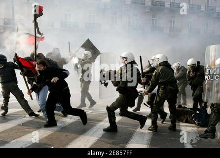 Self-styled anarchists armed with wooden sticks fight against the police in an attempt to release an arrested comrade (on the floor) in a cloud of tear gas outside the Greek Parliament in Athens February 22, 2007. Clashes erupted after protesters tried to break a police cordon as thousands of students marched through Athens to protest government plans to reform higher education and introduce private universities.  REUTERS/Yannis Behrakis (GREECE)