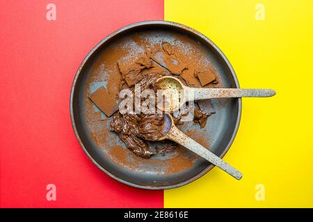 crème de cacao noisette et morceaux de chocolat mélangés dans un bol sur fond jaune et rouge. vue de dessus Banque D'Images
