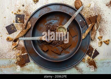 crème de cacao aux noisettes et morceaux de chocolat mélangés dans un bol sur fond de bois clair. vue sur le dessus Banque D'Images