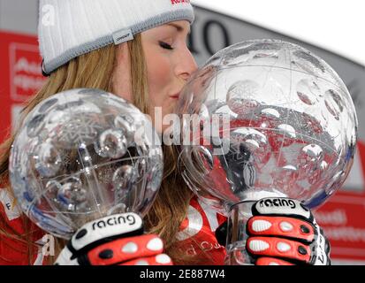 Lindsey Vonn of the U.S. kisses the women's World Cup overall trophy (R) as she poses for the photographers on the podium with the downhill trophy in the other hand during the World Cup Alpine ski finals in Bormio March 16, 2008. Vonn won ahead of Nicole Hosp of Austria and Maria Riesch of Germany.   REUTERS/Alessandro Bianchi  ( ITALY )