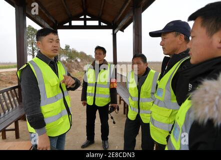 (210131) -- NANCHANG, le 31 janvier 2021 (Xinhua) -- Lei Xiaoyong (1er L) et ses collègues discutent de la route de patrouille à la ferme Kangshan du comté de Yugan, dans la province de Jiangxi, en Chine orientale, le 30 janvier 2021. Lei Xiaoyong est chef de la station de protection des animaux sauvages et des végétaux de l'administration forestière du comté de Yugan. L'une des tâches de Lei et de ses collègues est de protéger les oiseaux migrateurs du lac Poyang, le plus grand lac d'eau douce de Chine et un lieu d'hivernage important pour la sauvagine en Asie. Au cours de cet hiver, un grand nombre de grues blanches ont menti à la ferme de Kangshan à Yugan pour l'hivernage, avec Banque D'Images