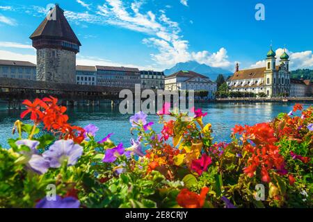 Destination touristique et de voyage incroyable à Lucerne. Jolie église Jesuitenkirche avec rivière Reuss. Vue sur le front de mer avec pont en bois fleuri de la chapelle, Banque D'Images