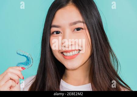 Portrait jeune asiatique belle femme souriante tenant des pièces de retenue orthodontiques en silicone pour les dents, les dents retenir les outils après les bretelles amovibles, Orthodonont Banque D'Images