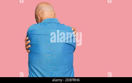 Homme bald d'âge moyen portant des vêtements décontractés s'embrassant heureux et positif de l'arrière-plan. Amour de soi et soin de soi Banque D'Images
