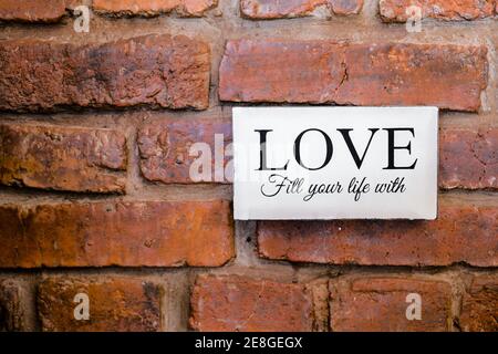 plaque signalétique avec signe d'amour sur le mur de briques. Banque D'Images
