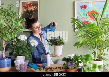 Femme s'occupant des plantes d'intérieur, des passe-temps et des loisirs, de la nature dans la maison Banque D'Images