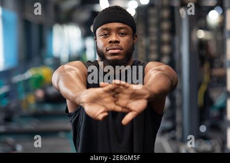 Un sportif s'étire les mains avant de s'entraîner à la salle de gym Banque D'Images