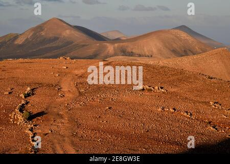 Paysage volcanique coloré avec un sentier de randonnée près de Yaiza au soleil du soir. Lanzarote, Îles Canaries, Espagne. Banque D'Images