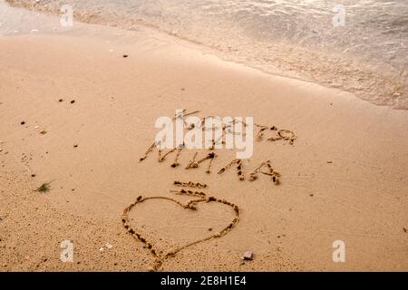 Déclaration d'amour sur le sable de la plage. Le lettrage des noms équivaut à l'amour Banque D'Images