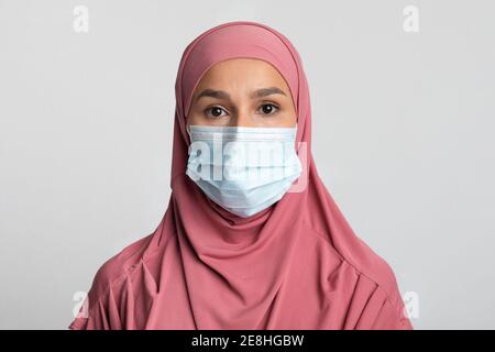Coronavirus et Islam. Femme musulmane religieuse en hijab portant un masque médical de protection Banque D'Images