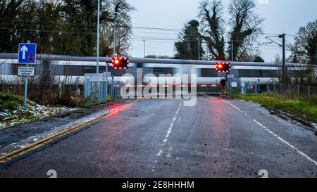 Le train Greater Anglia passe par un passage à niveau en milieu d'hiver, au niveau du chemin de fer britannique, près de Cambridge. Passage à niveau fermé. Banque D'Images
