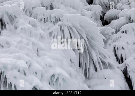 Éclaboussures d'eau glacée couvrant la pente de la falaise rocheuse près Lac Baikal le jour d'hiver Banque D'Images