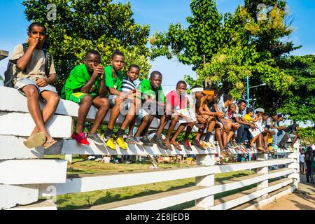 Des garçons sur un mur regardant le défilé de Carneval dans la ville de Sao Tomé, Sao Tomé-et-principe, océan Atlantique Banque D'Images