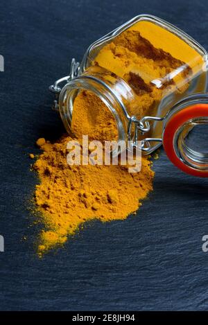 Turmericpoder ( Curcuma longa) avec récipient en verre Banque D'Images