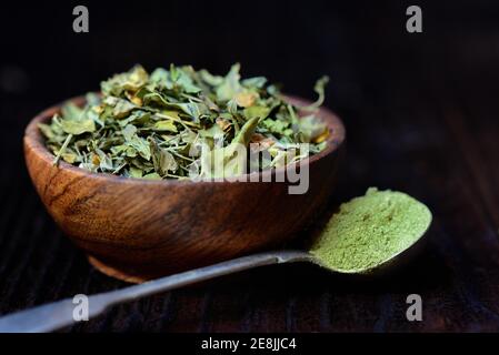 Feuilles de Moringa dans un bol et poudre de moringa dans une cuillère Banque D'Images