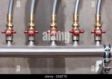 Nœud du système d'alimentation en eau sur le fond d'un mur en béton, en gros plan Banque D'Images