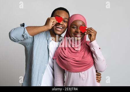 Mélomanes joueurs couvrant un œil avec des coeurs rouges Banque D'Images